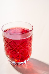 Stewed fruit red compote drink in textured transparent glass