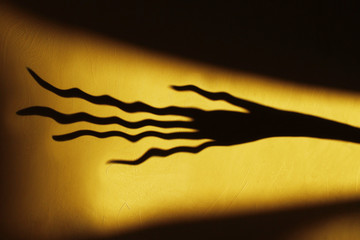 Blurred Strange Shadow On The Wall.Terrible Shadow. Abstract Background. Black Shadow Of A Big Hand...