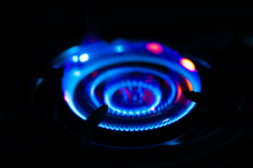 Blue of fire burning in kitchen on the dark background.