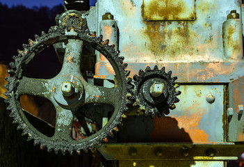 Vintage oily and rusty cogwheel at night