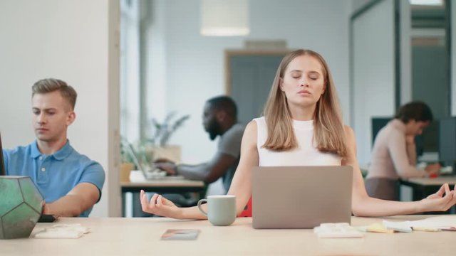 Business woman relaxing after work in office. Exhausted woman making yoga breath