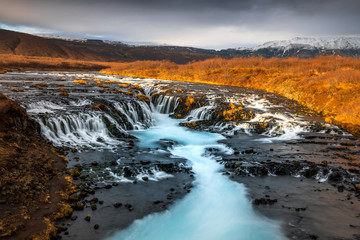 Landscape in Iceland waterfall sun mountains light golden hour road