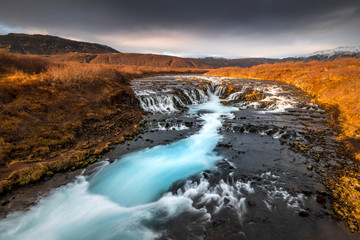 Landscape in Iceland waterfall sun mountains light golden hour road