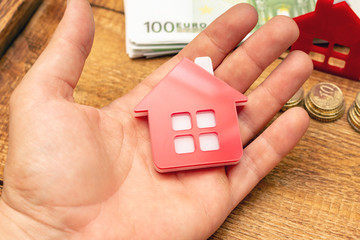 Hand holding house home and money real estate concept, real estate expenses, property expenses, buying a property mockup copy space close up background