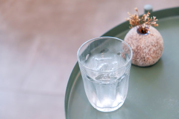 Cold glass of water on wooden table at cafe