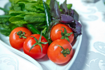Tomato salad and herbs . Fresh tomatoes . Vegetable salad in the plate .