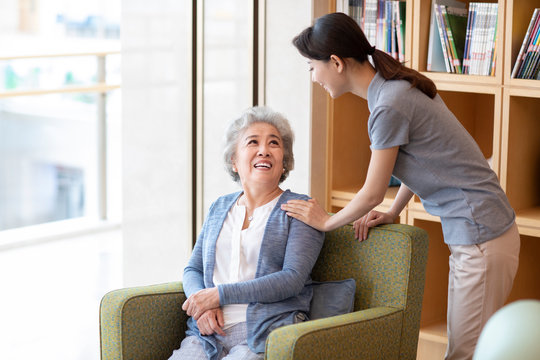 Nursing assistant taking with senior woman in nursing home