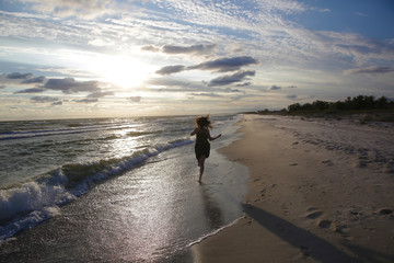Naklejka premium Woman on the sea coast on sunset
