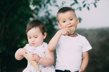 Cute kids Brother and sister are very cute outside in summer eating ice cream in the horn