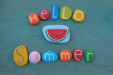 Hello Summer text composed with multi colored sea stones over green sand