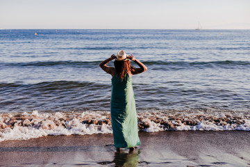 young beautiful woman walking by the beach at sunset. Relax and holidays concept