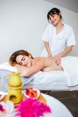 Obraz na płótnie Canvas attractive woman getting a relaxing massage at a home spa