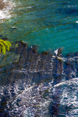 rocky sea shore with pebble beach, waves with foam