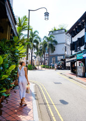 Girl tourist walks the streets of Singapore and admires the views