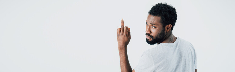 angry african american man in grey t-shirt showing middle finger isolated on grey - obrazy, fototapety, plakaty