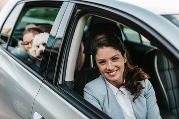Young businesswoman with her daughter in a car.
