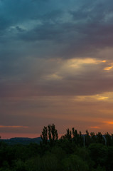 Landscape with dramatic light - beautiful golden sunset with saturated sky and clouds.