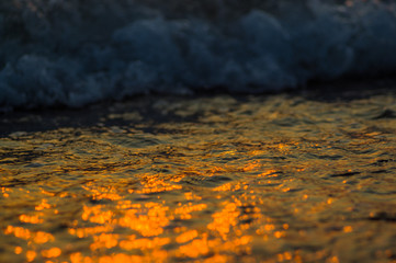Amazing sea sunset on the pebble beach, the sun, waves, clouds