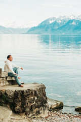 Fototapeta na wymiar Portrait of handsome man admiring beautiful lake with mountains, wearing white sweatshirt