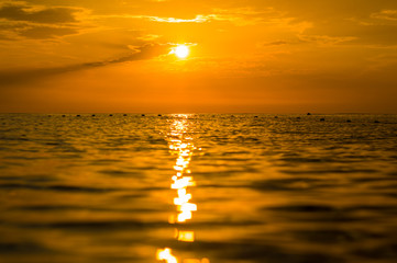 Amazing sea sunset on the pebble beach, the sun, waves, clouds