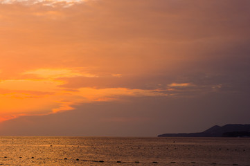 Obraz premium Amazing sea sunset on the pebble beach, the sun, waves, clouds