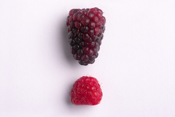 Exclamation mark made from blackberries and raspberries. Food background with summer berries.