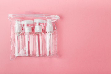 Travel small bottle set on pink background. Top view, copy space