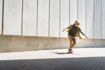 adult man riding on skateboard near concrete wall