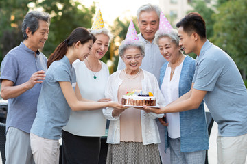 Young nurses bringing birthday cake to seniors