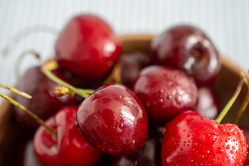Close-up detail of fresh cherries in wooden bowl
