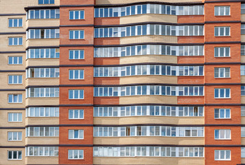 Fototapeta na wymiar The facade of a high-rise residential building close-up.