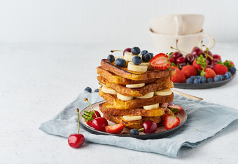 French toasts with berries and banana, brioche breakfast, white background, closeup