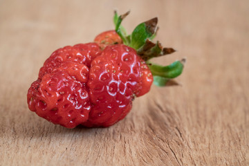 unusual shaped strawberry on a wooden table