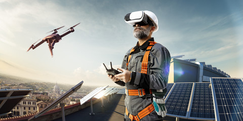 Happy engineer using drone and vr helmet for cheking solar station. in roof