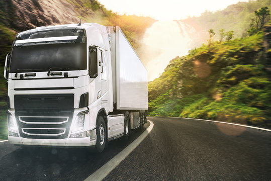 White Truck Moving On The Road In A Natural Landscape At Sunset