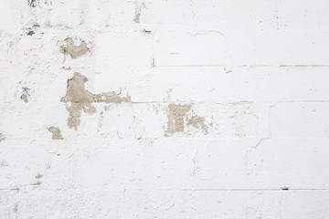 abstract background of wall of concrete blocks painted white with translucent old paint