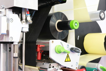 Fragment of the conveyor of sticking labeling machine. Abstract industrial background.