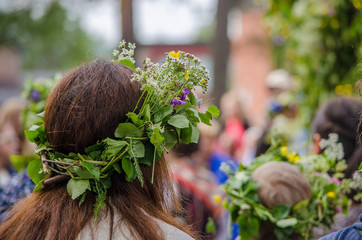 Woman enjoying swedish traditional mid summerday in a sunny day with colourful flower crown