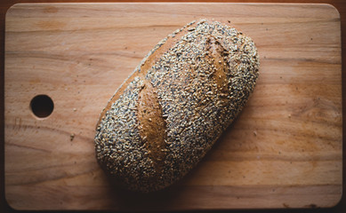 Multigrain homemade bread on a wooden cutting board at home