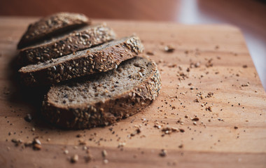 Sliced multigrain homemade bread on a wooden cutting board at home