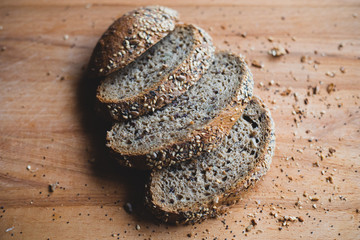 Sliced multigrain homemade bread on a wooden cutting board at home