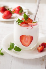 Yogurt with strawberry on wooden table