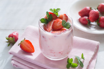Yogurt with strawberry on wooden table