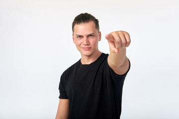 Gesture. Young handsome confident smiling man pointing at you. I choose you. I want you. Studio shot on white background.