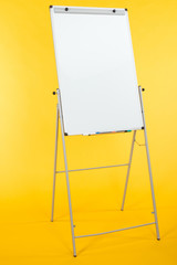 white flipchart with copy space isolated on yellow - obrazy, fototapety, plakaty