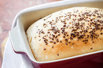 Homemade wheat bread with flax seeds in ceramic baking dish