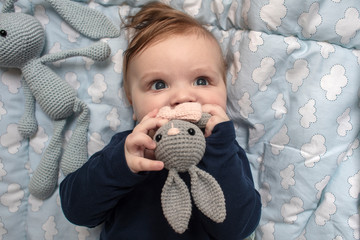Beautiful baby in the crib with a toy before a sleeping. Baby play with a toy. Baby teeth grinding....