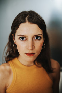 Portrait of young brunette womanportrait of confident looking brunette woman wearing a yellow top