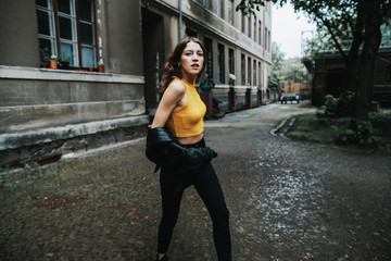 portrait of confident brunette woman running outdoors in an urban setting