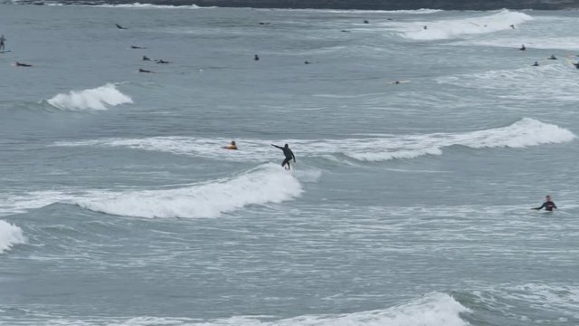 Surfer rides on high waves at Croyde Beach in the UK